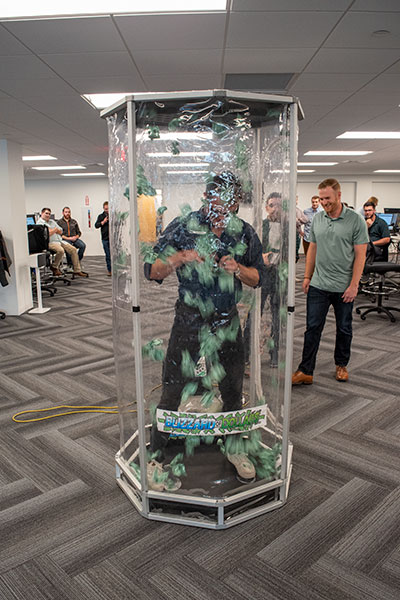 employee standing inside a money tornado trying to catch play money