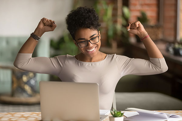 female employee sitting at her laptop flexing her arms