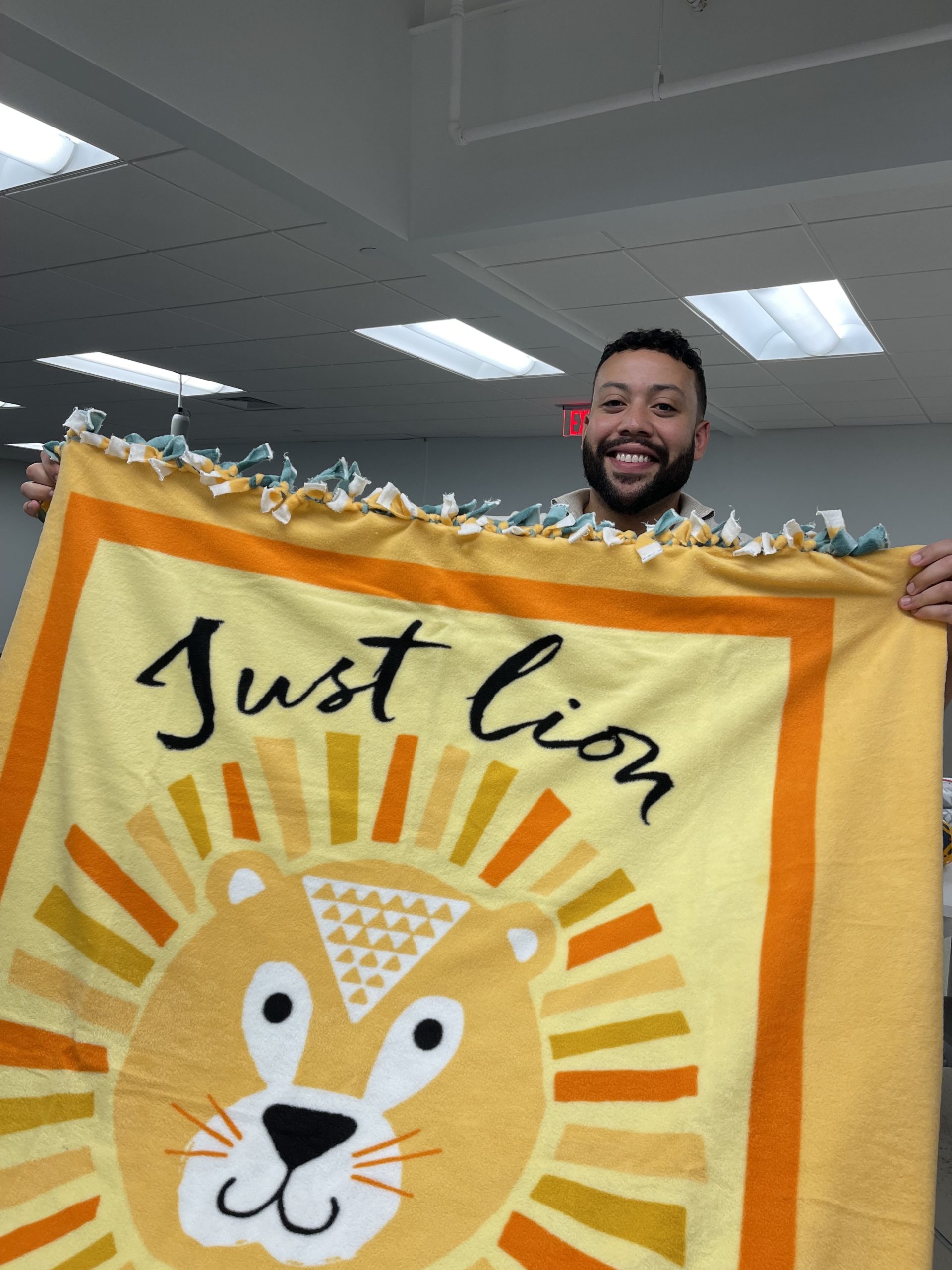 Reveneer employee holding a blanket that says Just Lion