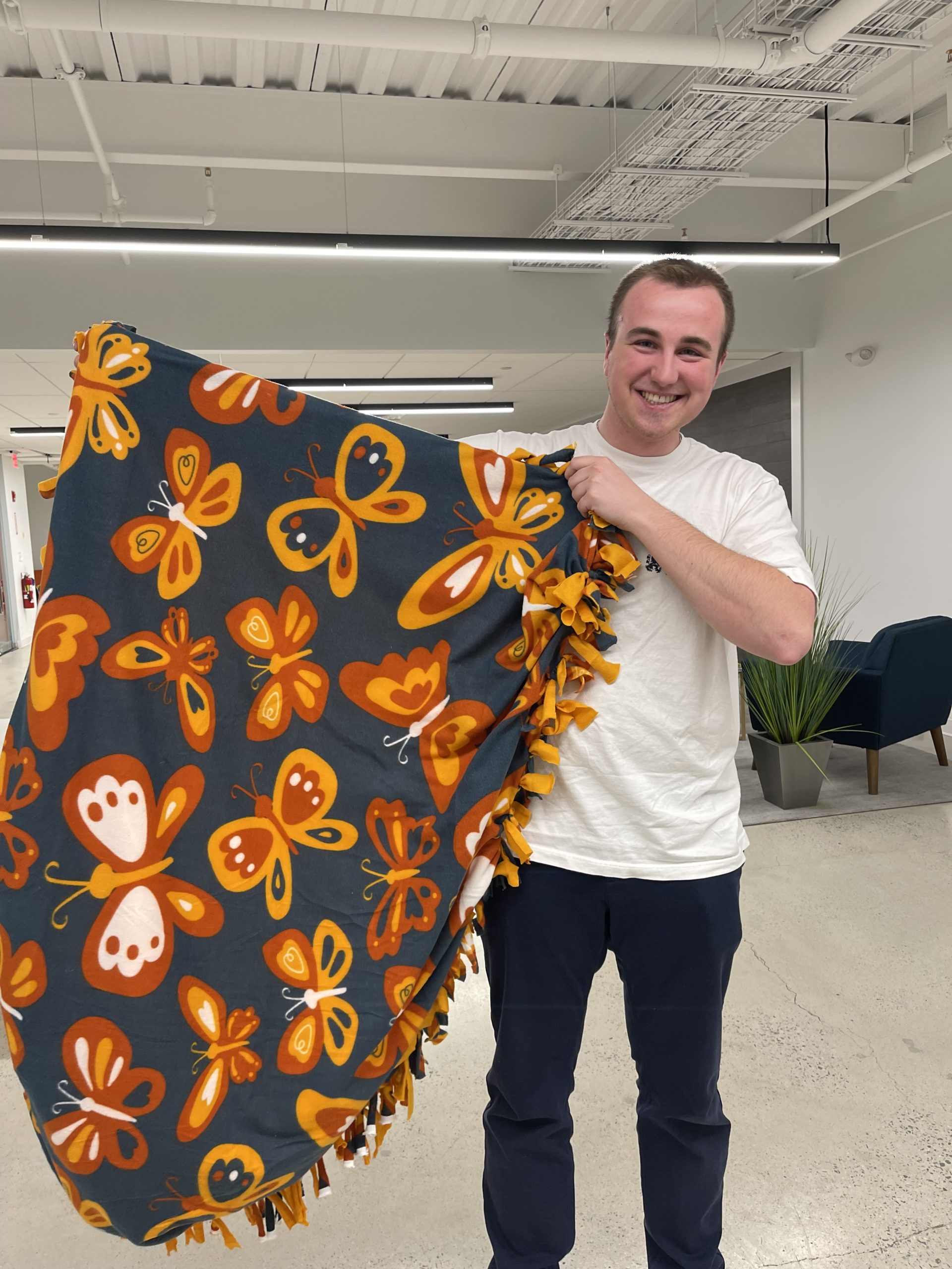Reveneer employee holding a butterfly blanket