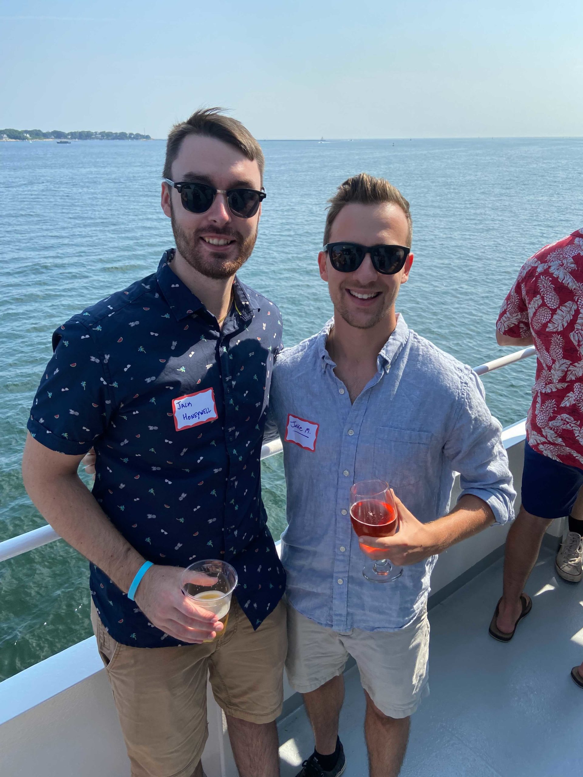 two Reveneer employees on a boat holding drinks
