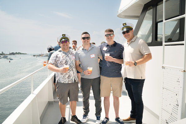 four male Reveneer employees standing in a boat