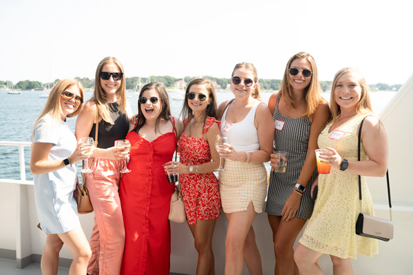 Group of female Reveneer employees on a boat holding drinks