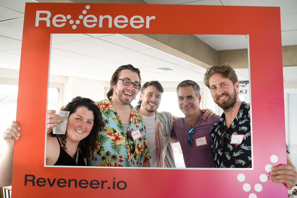 Reveneer employees standing inside a Reveneer photo frame