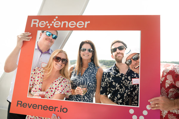 Reveneer employees on a boat standing inside a Reveneer photo frame