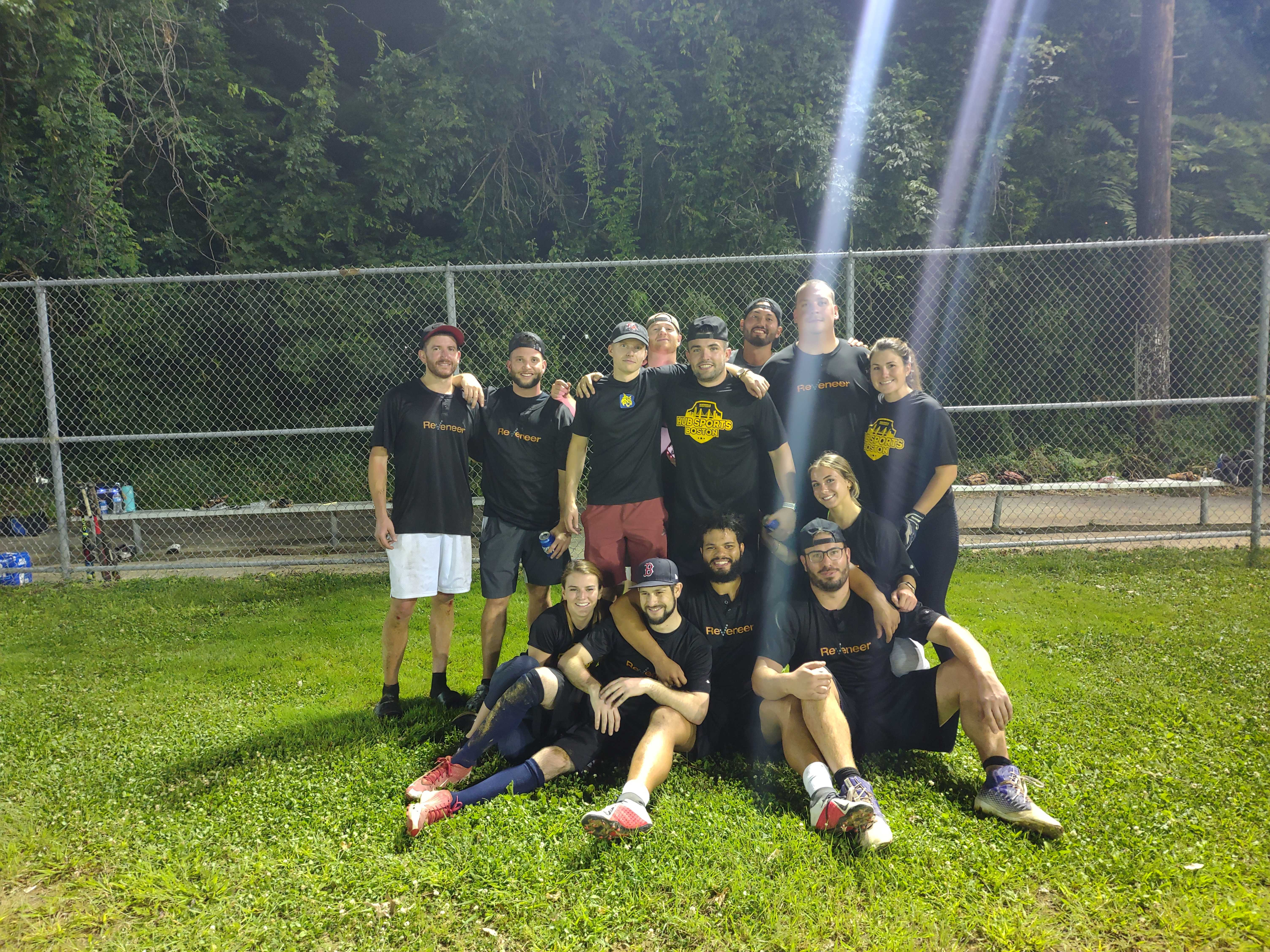 Reveneer employees in a group photo on a baseball field